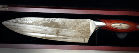 knife with detailed photo of a golf course etched onto the blade